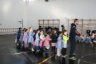 Marco Rossi con gli alunni della scuola, guida la fila al tiro della sua squadra